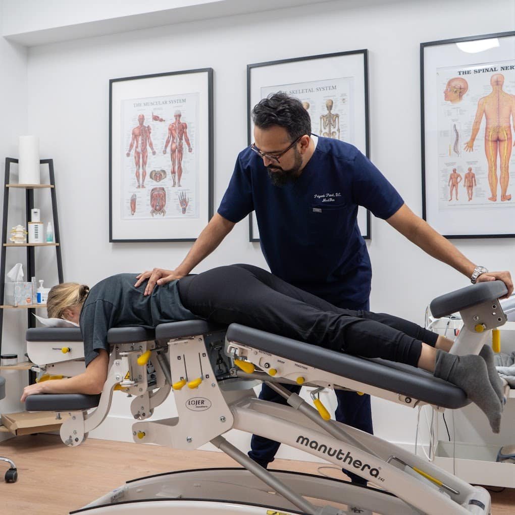Dr. Priyank Patel using the Manuthera 242 mobilization table for advanced spinal decompression in Brooklyn