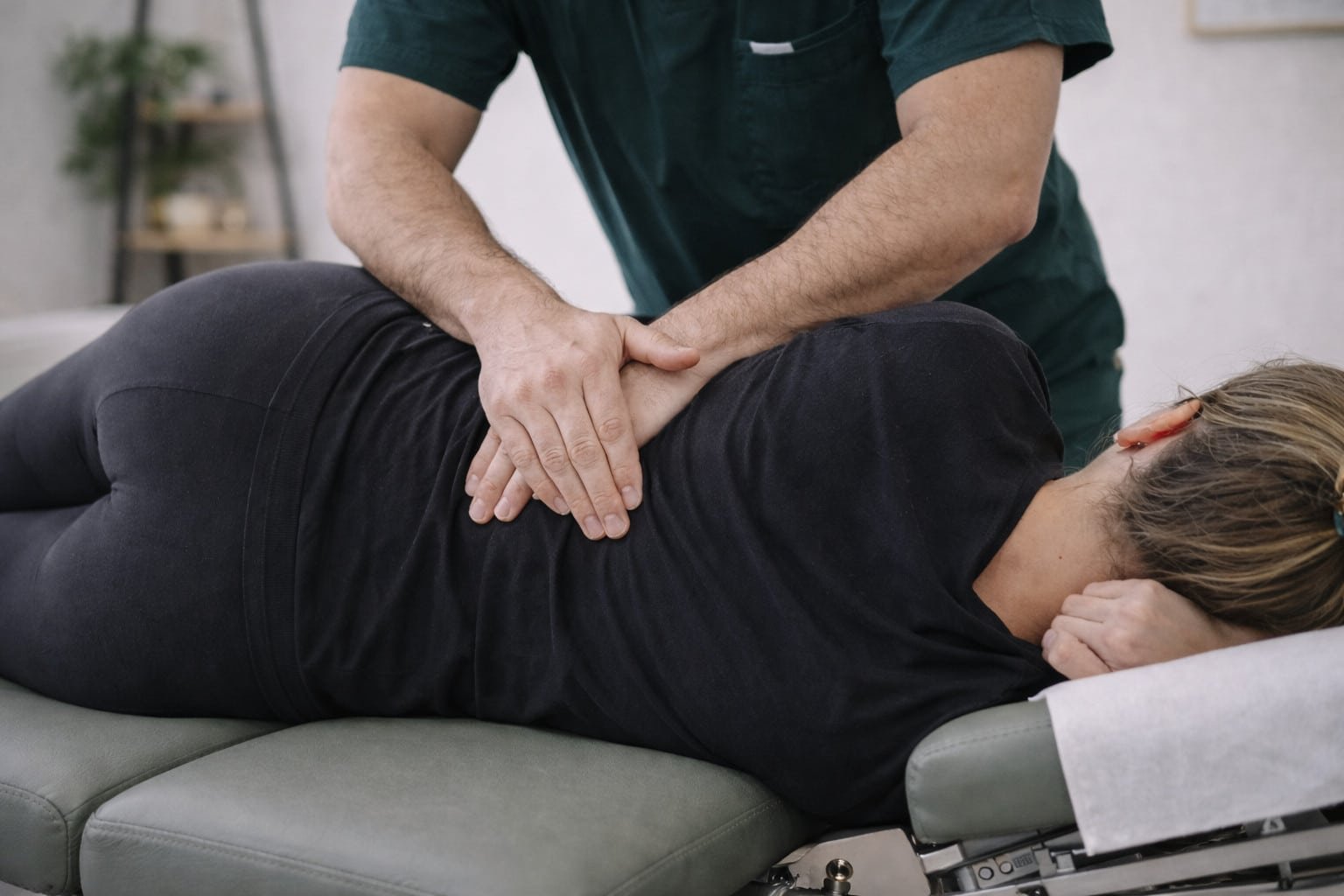 Chiropractor performing a manual lumbar spine adjustment on a patient for lower back pain relief in Brooklyn