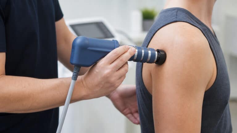 Radial shockwave therapy applied to the lateral shoulder for rotator cuff pain at Brooklyn Chiropractic Care in Greenpoint
